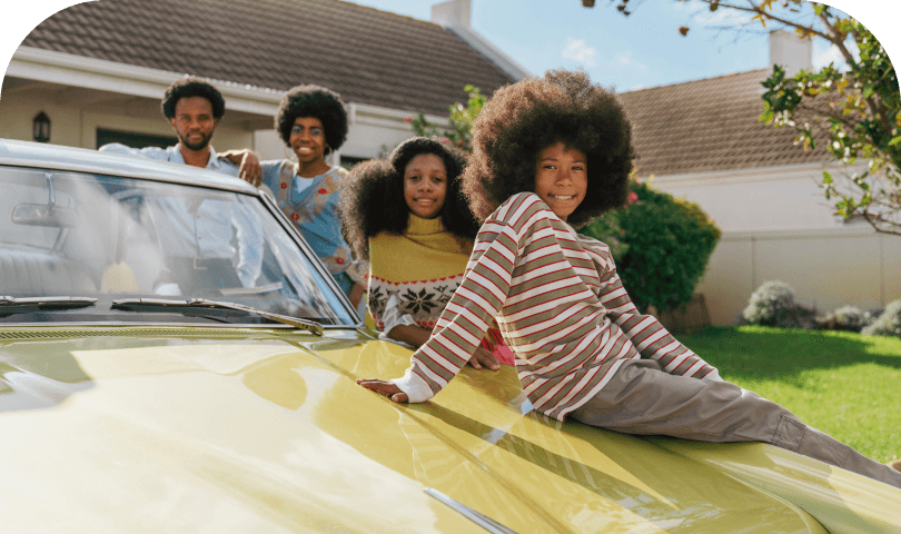 Family sitting near a car outdoors